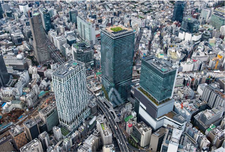 渋谷スクランブルスクエアを中心とした渋谷を上空から撮影した写真。中央に渋谷スクランブルスクエアを含む3つの大きなビルがあり、その間を高速道路が通っている。