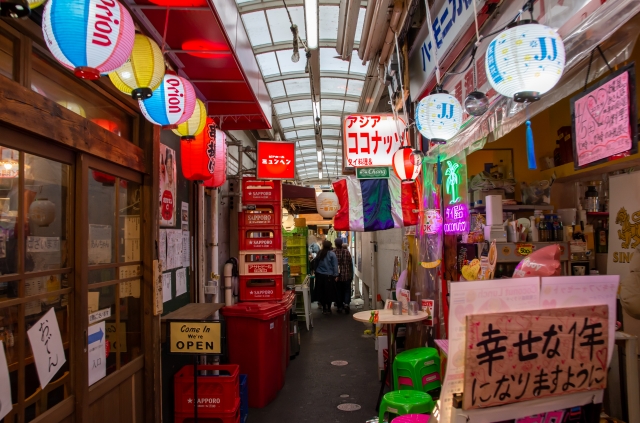 吉祥寺ハモニカ横丁アーケードの写真。道は狭く、左右に提灯の吊り下げられたお店がひしめき合う。