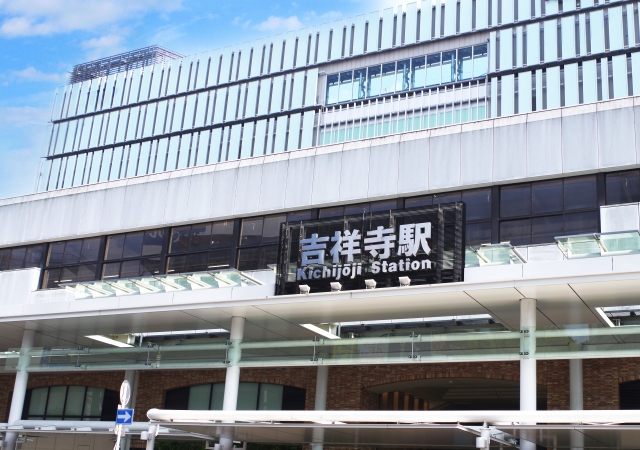 吉祥寺駅舎を外から撮影した写真。中心には吉祥寺駅と書かれた木製と思われる看板。