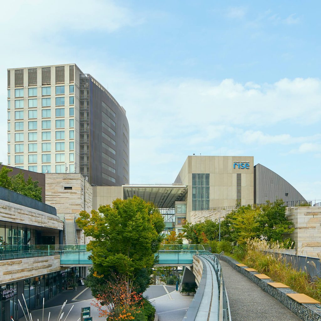 二子玉川ライズを外から撮影舌写真。奥に縦長のビル。手前に横長のビルがある。横長のビルは中心がアーケードになっている。